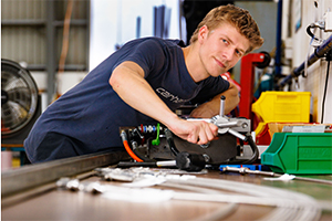 A Chisholm student focused on hands-on trades training, using tools and equipment in a workshop setting — featured in our student story highlighting real-world learning experiences.